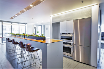 a modern kitchen with stainless steel appliances and a long island with a wood countertop